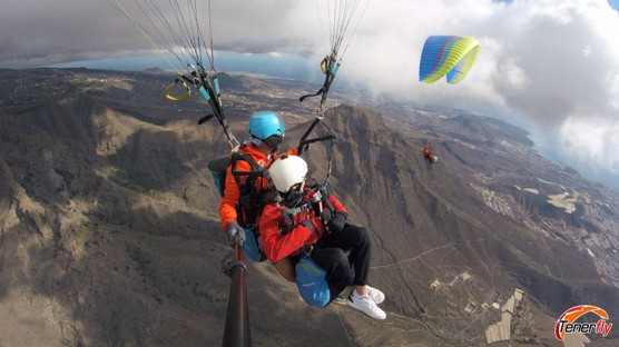 Aventura compartida: Pareja disfrutando del parapente sobre la montaña rocosa de El Conde en Tenerife